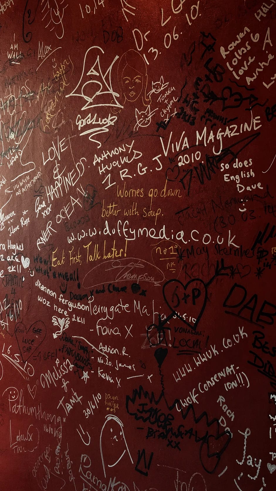 The signature wall at Wok & Flame, covered in messages from regulars